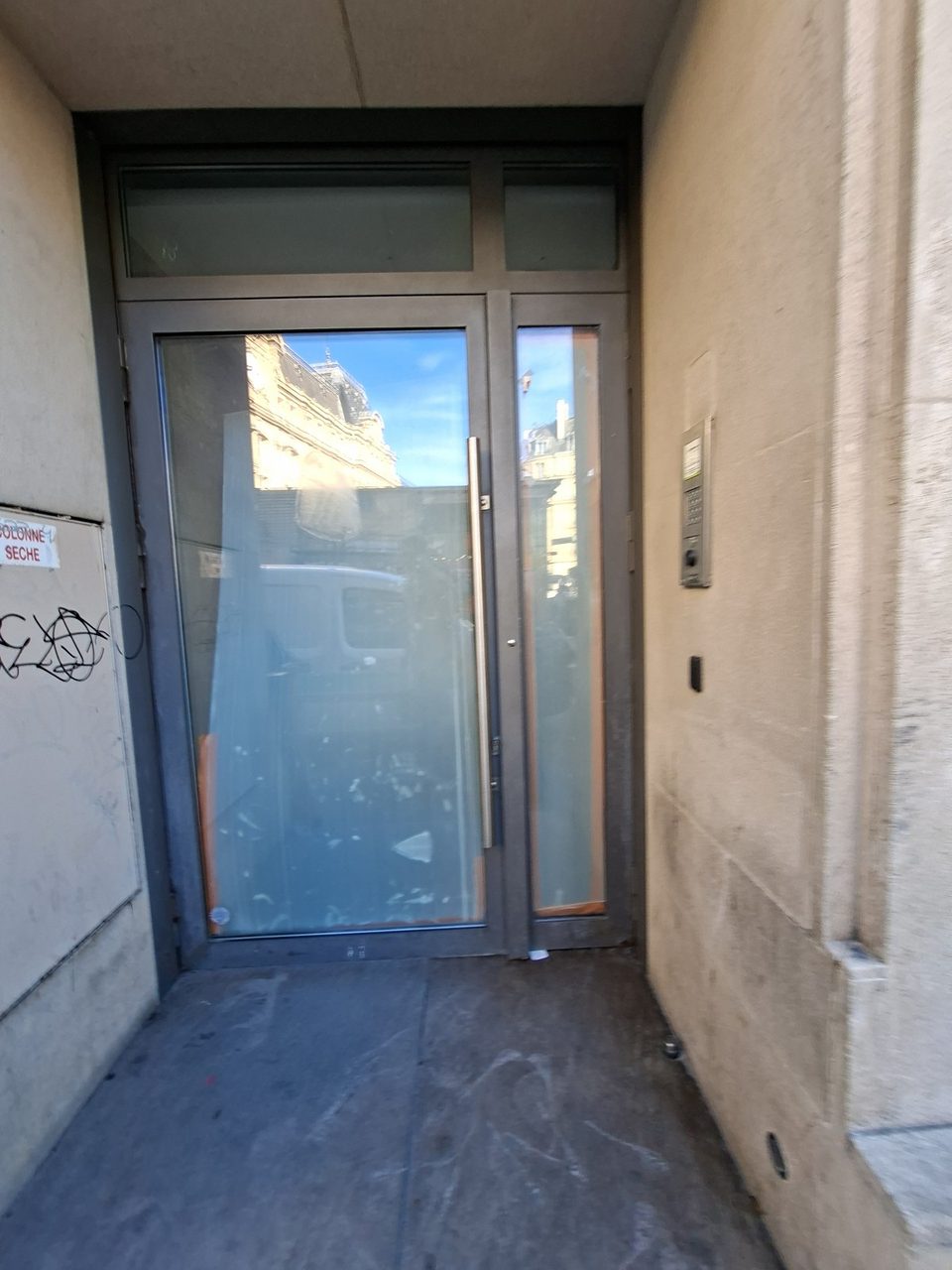 Entrée aujourd'hui, porte vitrée et pierre tachée